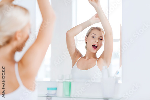 woman yawning in front of mirror at bathroom
