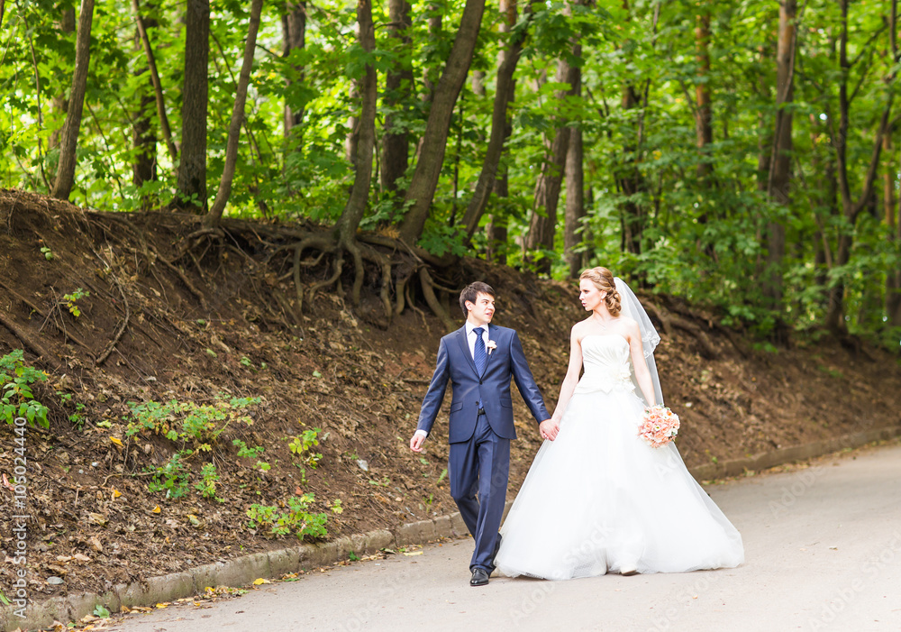 happy bride and groom at a park on their wedding day happy bride and groom at a park on their wedding day