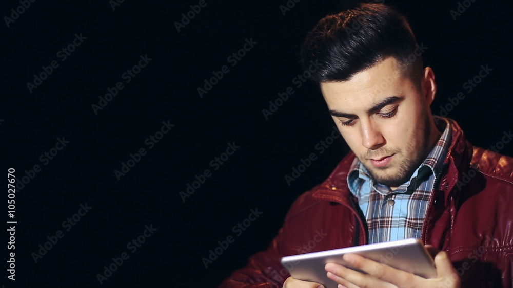 Young caucasian man with tablet computer in city at night Young caucasian man with tablet computer in city at night