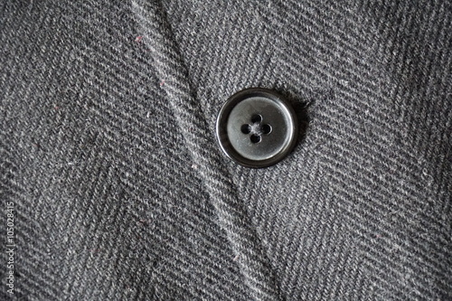 Detail of a dark button fastening the fish bone winter coat 