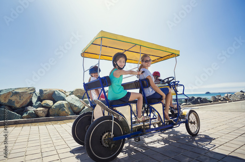 Family on a surrey bike ride along the coast of California © Brocreative