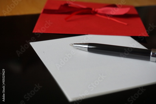 Black pen writing announcement letter with the decorated red envelope 