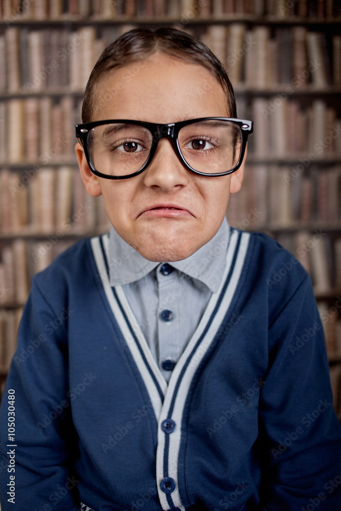 funny boy with eye glasses in library grumpy young boy in librar funny boy with eye glasses in library grumpy young boy in librar