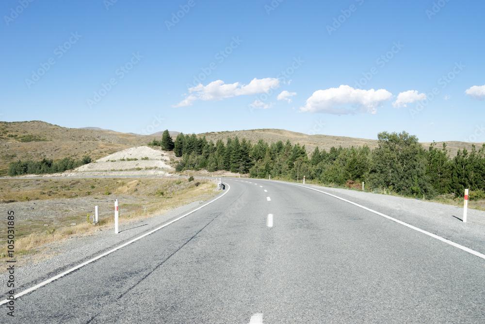 asphalt road near hill in summer day in New Zealand asphalt road near hill in summer day in New Zealand