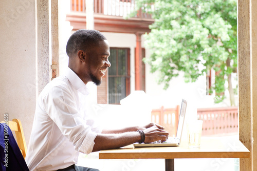 Handsome african businessman smiling with laptop