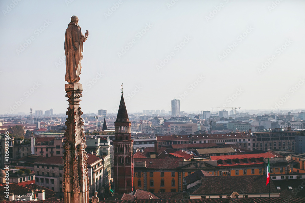 view from the roof of the Duomo to the statue and the city of Milan