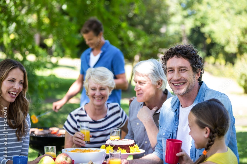 Family and friends having a picnic with barbecue Family and friends having a picnic with barbecue