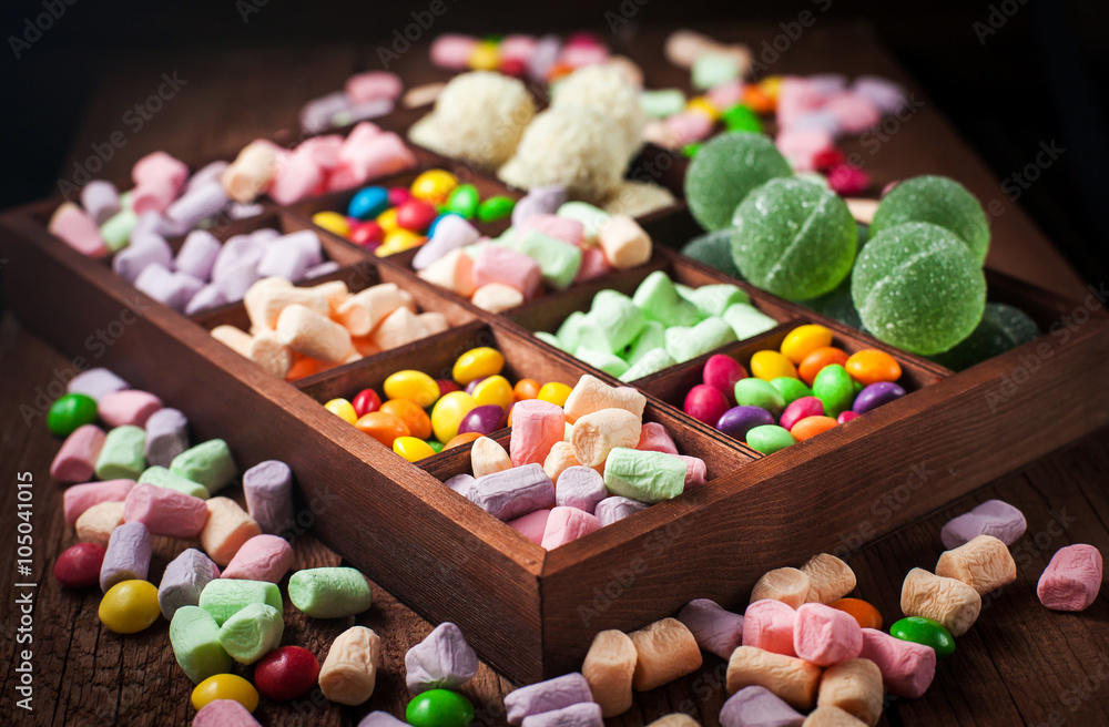 Mix of candies and sweets in wooden box Mix of candies and sweets in wooden box