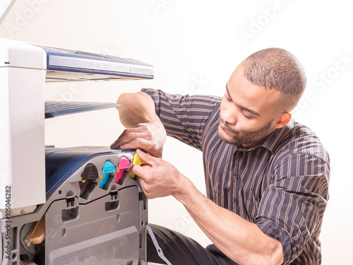 african man fixing photo copier