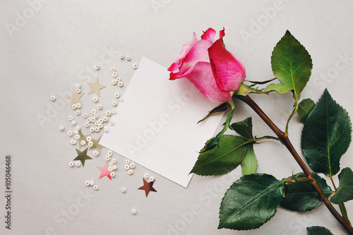 Роза и белый жемчуг на белом листке бумаги