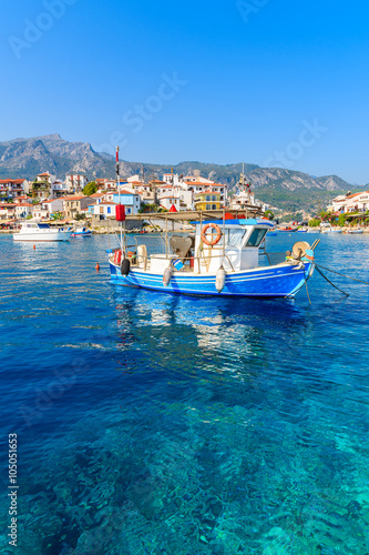 Typical blue and white colour fishing boat on azure crystal clear sea water in Kokkari port, Samos island, Greece