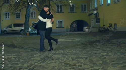 Young couple hugs underneath a Christmas tree in the middle of the night photo