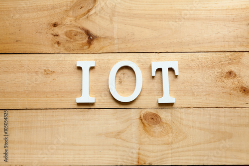 The acronym IOT Internet of things on wooden background