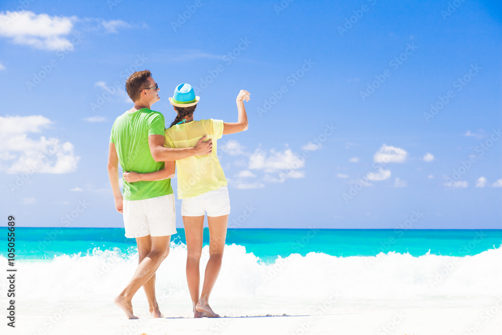 back view of happy romantic young couple holding hands on the beach back view of happy romantic young couple holding hands on the beach
