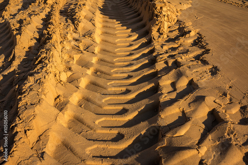 embossed trail excavator tracks on the wet sand.