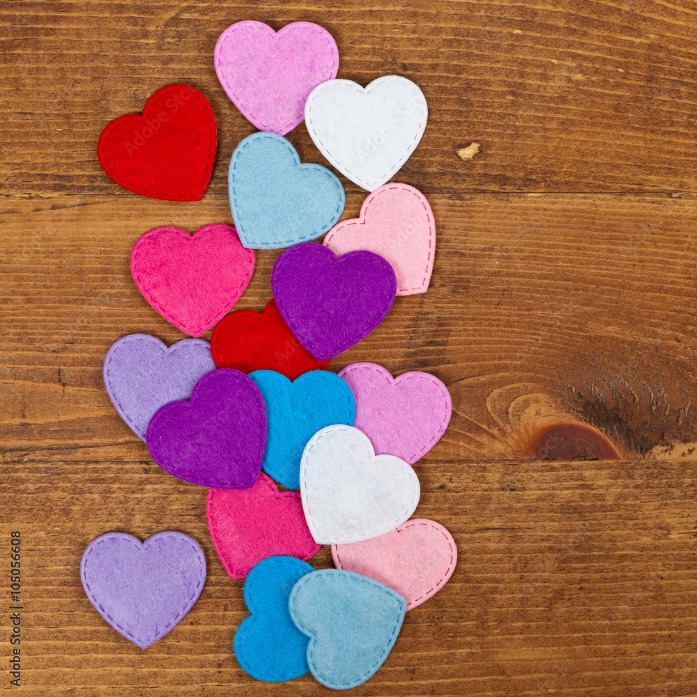 Obraz premium Valentines day background with toy hearts over wooden table. Selective focus.