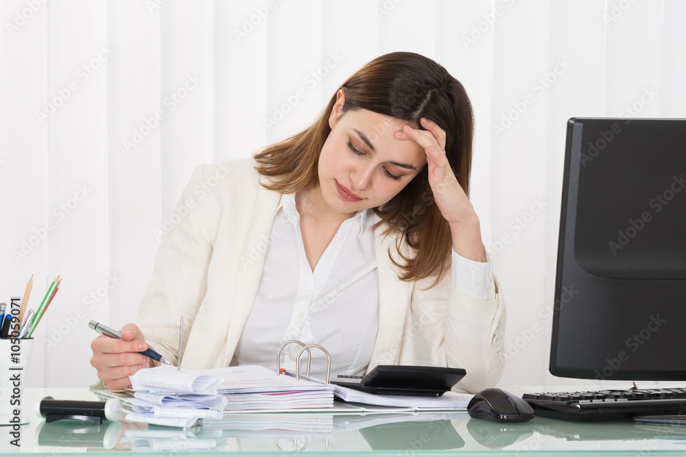 Depressed Businesswoman Calculating Invoice Depressed Businesswoman Calculating Invoice