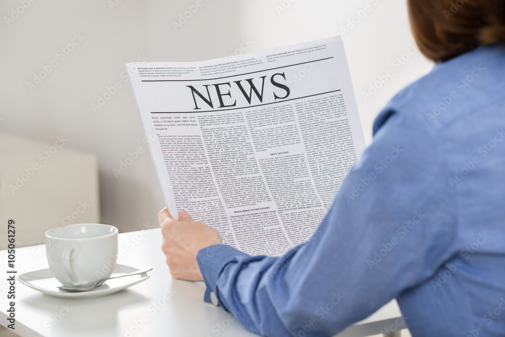 Naklejka premium Businesswoman Reading Newspaper In Office