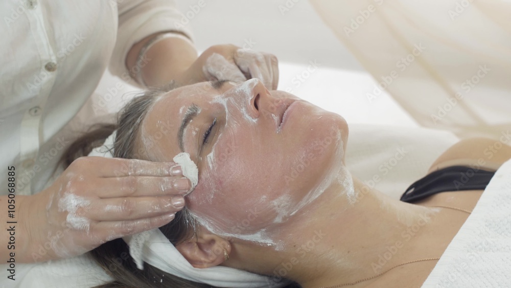 Close up cosmetologist hands, face wipe off clay mask out of girl face in beauty saloon. Cosmetic procedure Close up cosmetologist hands, face wipe off clay mask out of girl face in beauty saloon. Cosmetic procedure