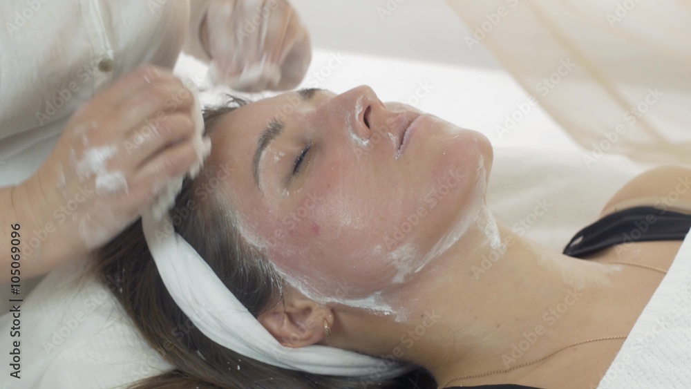 Close up of cosmetologist hands, face remove clay mask out of girl face in beauty saloon. Cosmetic procedure Close up of cosmetologist hands, face remove clay mask out of girl face in beauty saloon. Cosmetic procedure