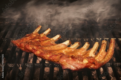 BBQ Roasted Baby Back Pork Ribs On Hot Flaming Grill photo