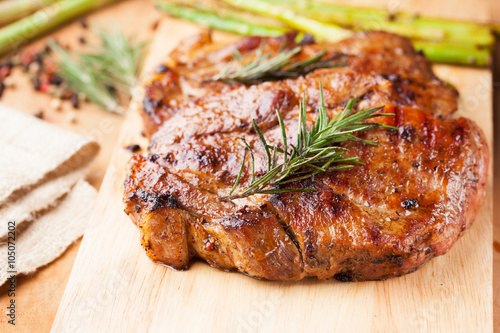 grilled pork chop with rosemary on wooden board