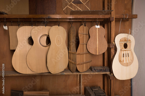 Parts of guitar hanging on the shelves at the factory