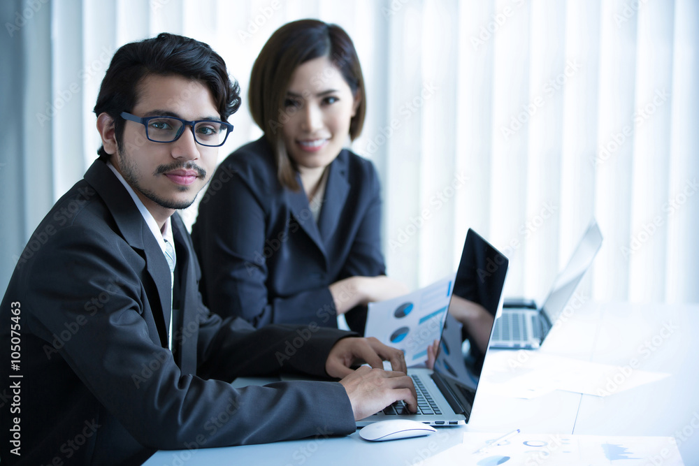 Asian businessmen are working in an office using a computer Asian businessmen are working in an office using a computer