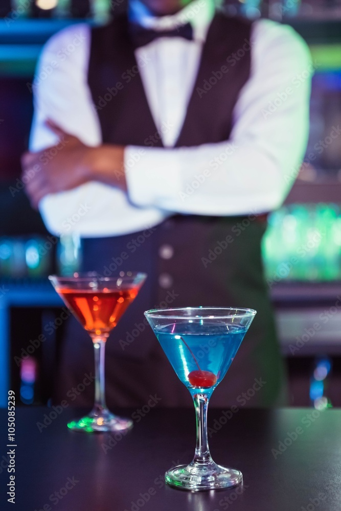 Blue and orange glasses of cocktail on bar counter