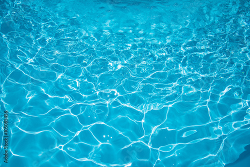 Beautiful blue water in swiiming pool with sun reflection