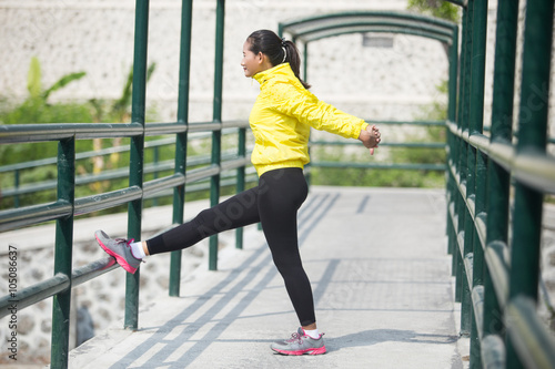 Young asian woman exercising outdoor in yellow neon jacket, stre