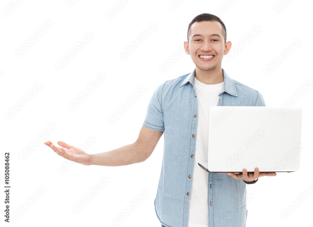 handsome young man holding a laptop while presenting copy space handsome young man holding a laptop while presenting copy space