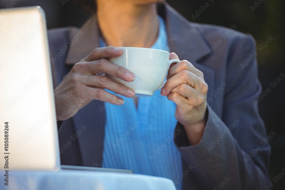 Woman having coffee using her laptop Woman having coffee using her laptop