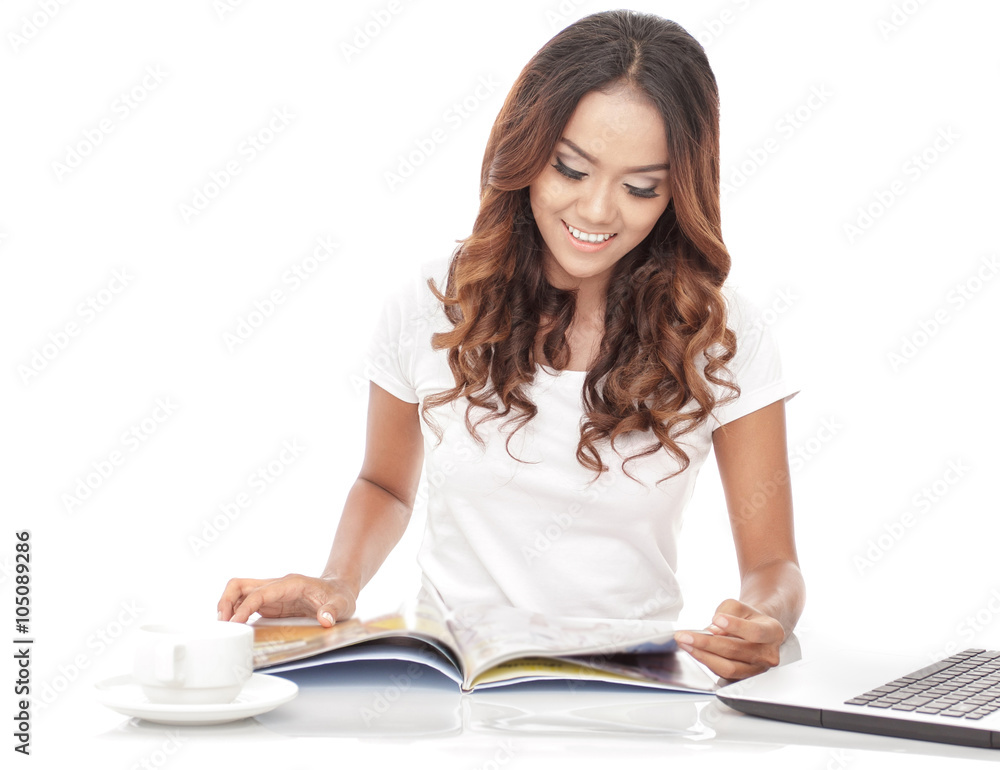 young woman reading a magazine while having a cup of tea young woman reading a magazine while having a cup of tea