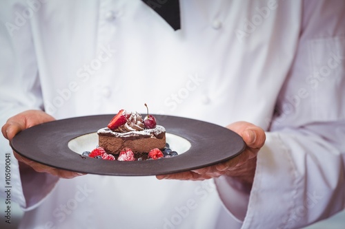 Photos Chef holding a plate with a dessert