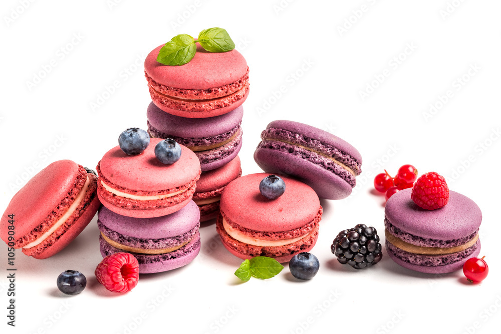 Delicious macaroons with berry fruits on white background