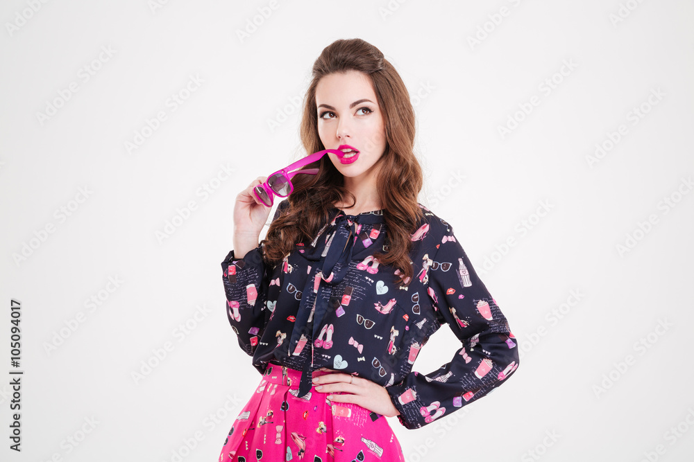 Thoughtful pretty young woman thinking and holding pink sunglasses Thoughtful pretty young woman thinking and holding pink sunglasses