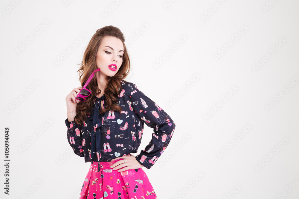 Sensual beaautiful young woman standing and holding pink sunglasses Sensual beaautiful young woman standing and holding pink sunglasses