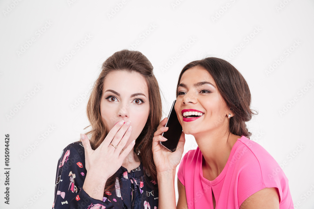 Shocked woman overhearing conversation of cheerful female with mobile phone Shocked woman overhearing conversation of cheerful female with mobile phone