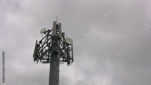 Timelapse of the upper section of a mobile phone communications tower with fast moving dark clouds in the background.