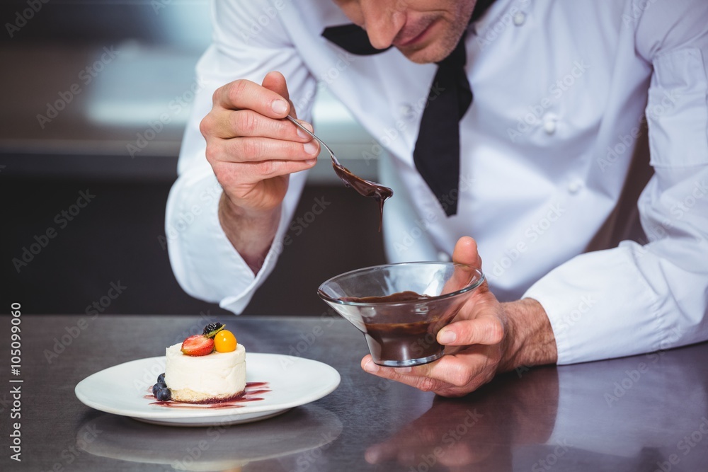 Chef putting chocolate sauce on a dessert Chef putting chocolate sauce on a dessert