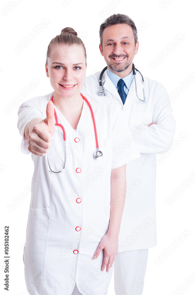 Attractive female doctor thumbup with male doctor on her back Attractive female doctor thumbup with male doctor on her back