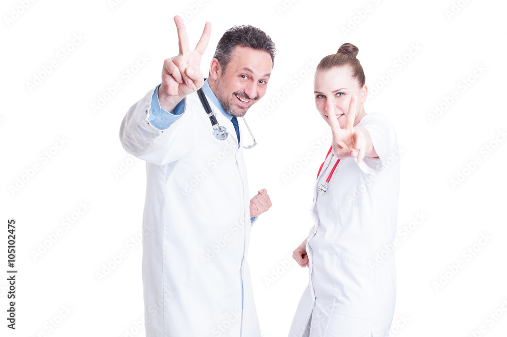 Young joyful medical coworkers gesturing victory Young joyful medical coworkers gesturing victory