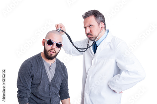 Male doctor consulting a crazy patient with stethoscope