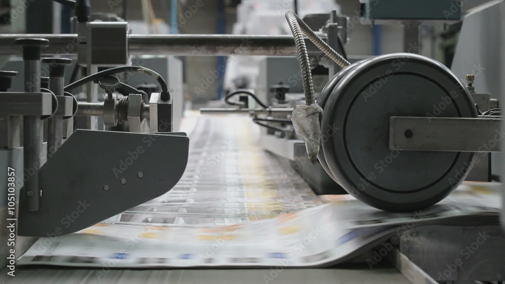 Industrial folding of leaflets and magazines at a rotary press factory Industrial folding of leaflets and magazines at a rotary press factory