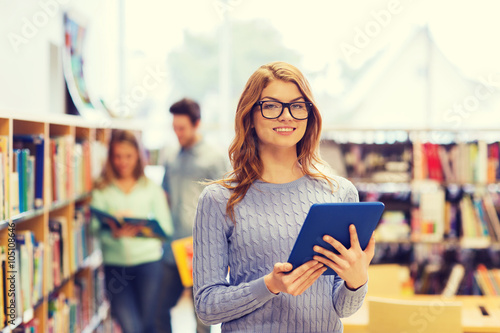 happy student girl with tablet pc in library