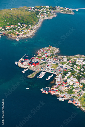 Amazing view of Lofoten islands: village Reine with red wooden houses near water from height 
