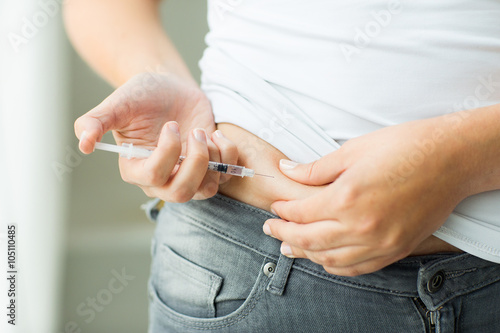 woman with syringe making insulin injection