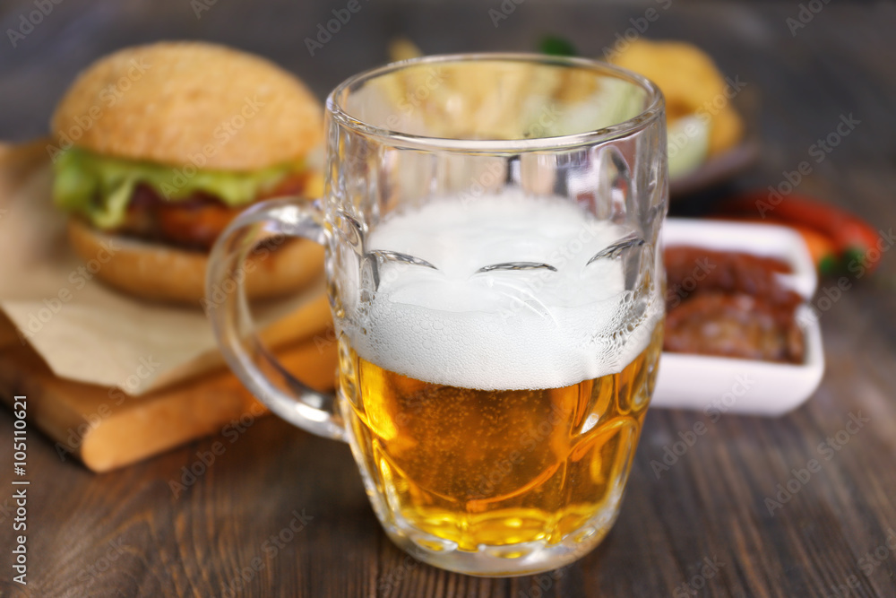 Glass mug of light beer with snacks on dark wooden table, close up Glass mug of light beer with snacks on dark wooden table, close up