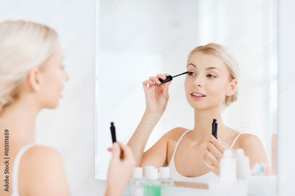woman with mascara applying make up at bathroom woman with mascara applying make up at bathroom